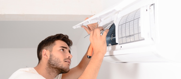 A guy checking an AC unit | AC Filter