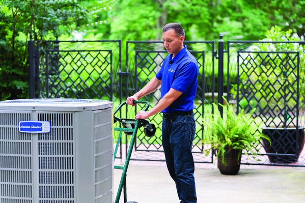 An HVAC contractor with a new air conditioning unit | AC Replacement Gainesville, FL